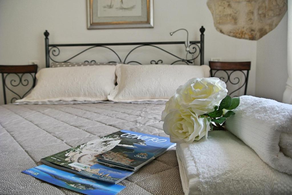 un letto con un libro e un fiore sopra di Sirolo tutto l'anno a Sirolo