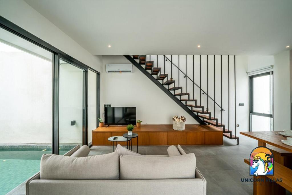 un salon avec un canapé et une télévision dans l'établissement Villa Akarui - by Unicorn Villas Bali, à Tumbak Bayuh