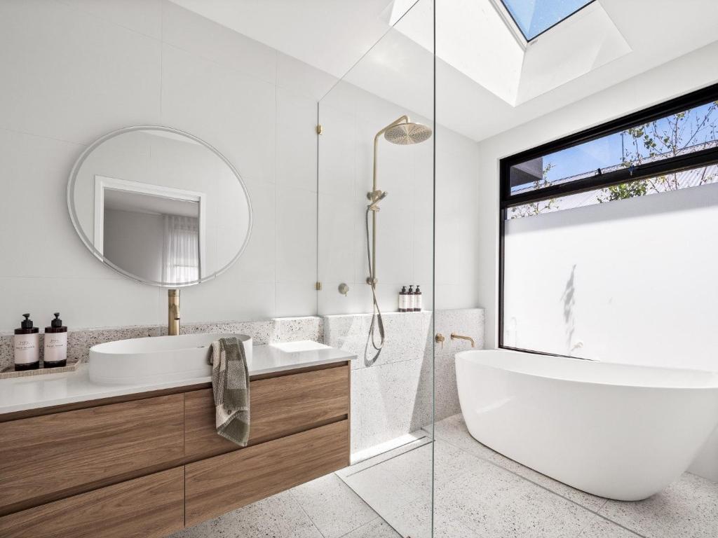 bagno con vasca, lavandino e specchio di Amila - central location with designed spaces a Dunsborough