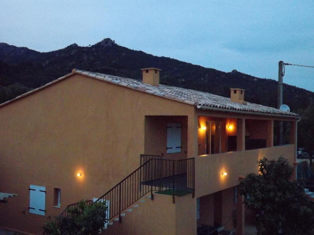 une maison avec un balcon donnant sur la montagne en arrière-plan dans l'établissement cASAPIANA 7, à Porto-Vecchio