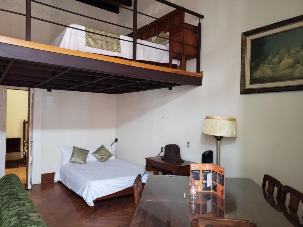 een slaapkamer met een hoogslaper, een bureau en een bed bij Aroma Hotel in Puebla