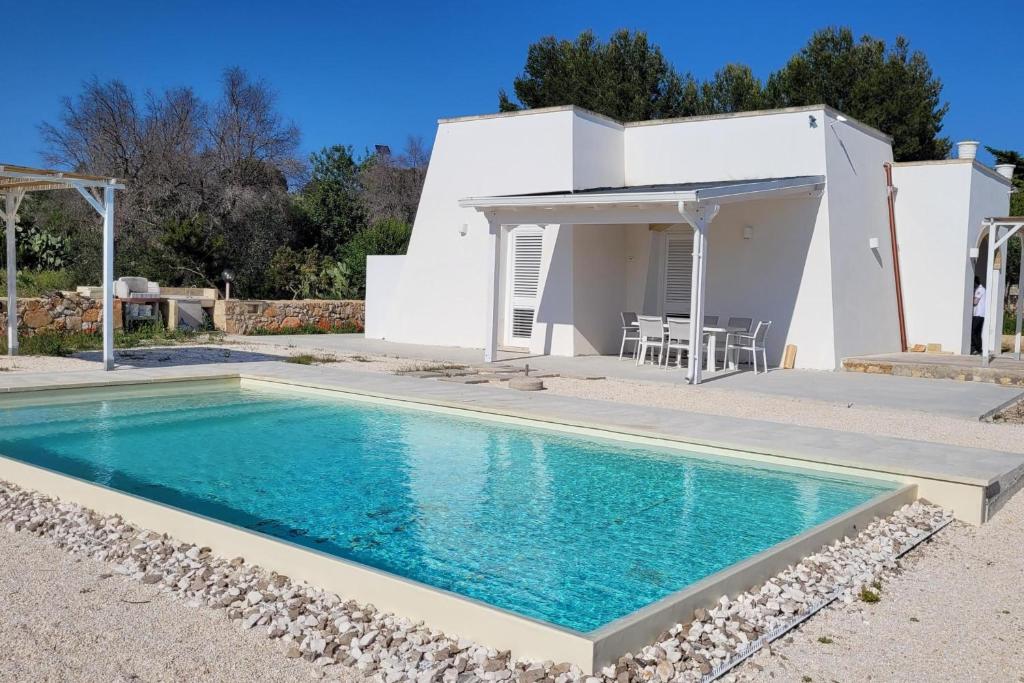 a villa with a swimming pool in front of a house at Villa Pescoluse with Pool and Sea View - Happy Rentals in Salve