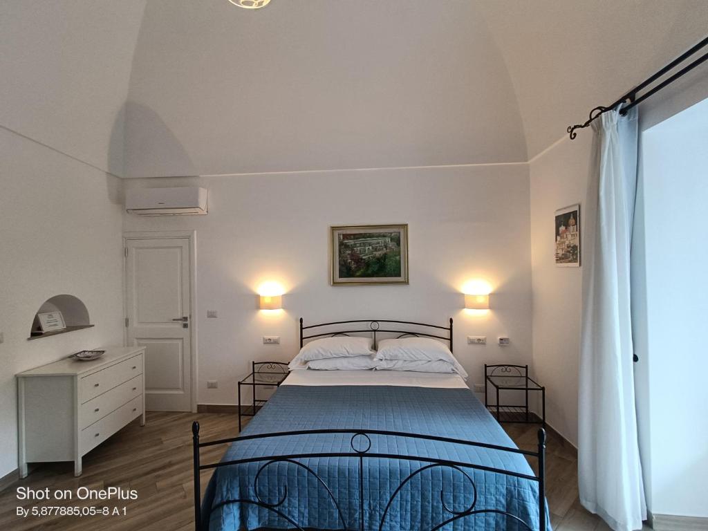 a bedroom with a bed and two lamps and a window at Regina Margherita in Positano