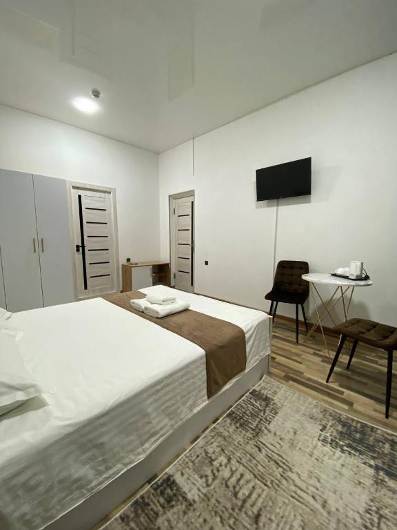 a bedroom with a bed and a desk and a television at shafranhotel in Tashkent