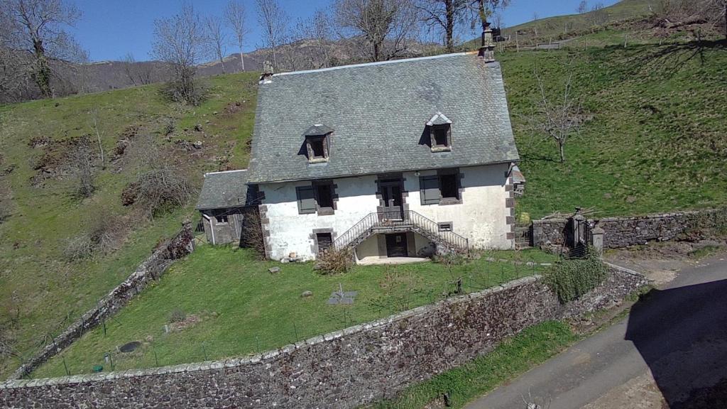 une vieille maison sur le flanc d'une colline dans l'établissement La ferme du Liaumiers, à Saint-Cirgues-de-Jordanne