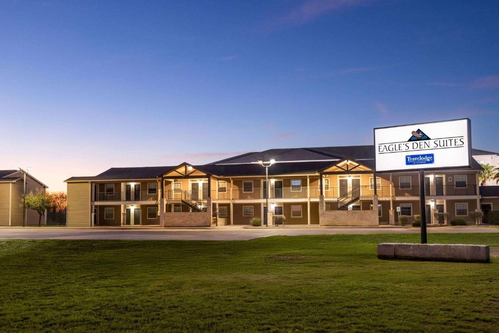 a building with a sign in front of it at Eagle's Den Suites Kenedy a Travelodge by Wyndham in Kenedy