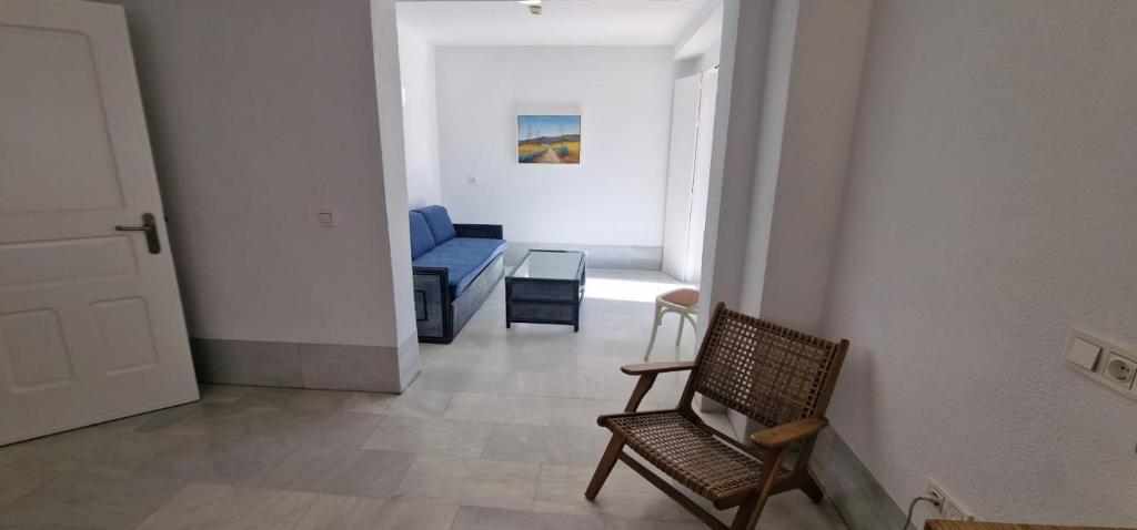 a hallway with a chair and a blue couch at Doña Pakyta in San José