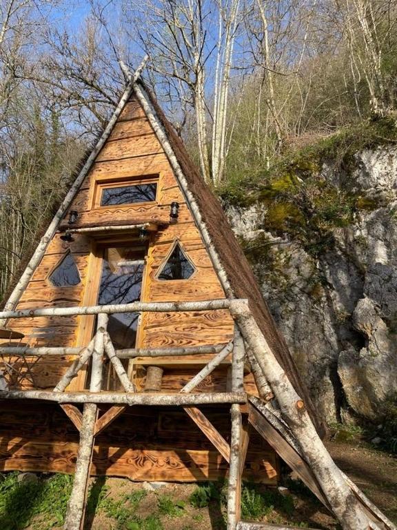 une cabane en rondins avec un toit triangulaire dans l'établissement D'tente skylodge SKALI, à Massat