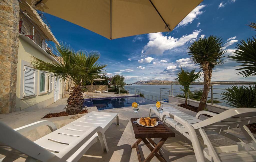 a patio with chairs and a table and an umbrella at Cozy Apartment In Vidalici in Kustići