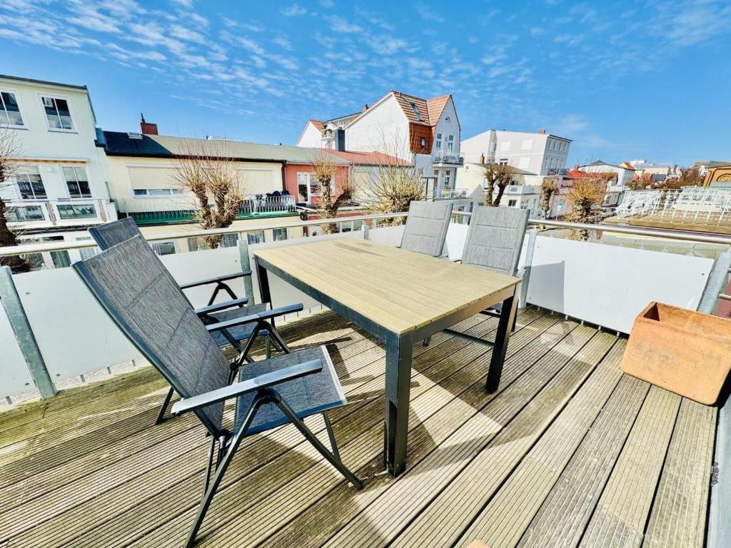 a wooden deck with a table and chairs on a balcony at Seerose in Warnemünde