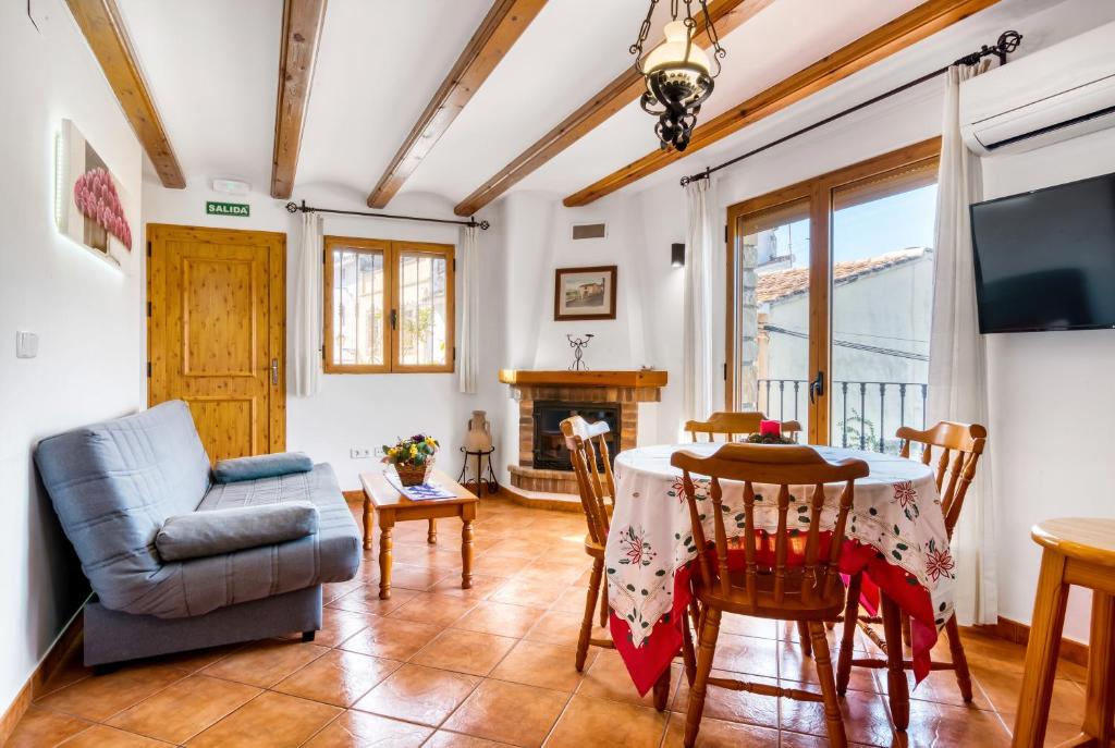 Una sala de estar con una mesa y sillas y un televisor. en Carrebaix Cavall Vert, en Orba
