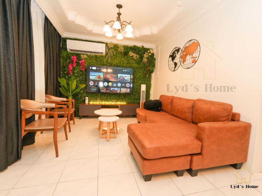 a living room with a couch and a tv at Lyd's Home Urban Staycation in Sibu