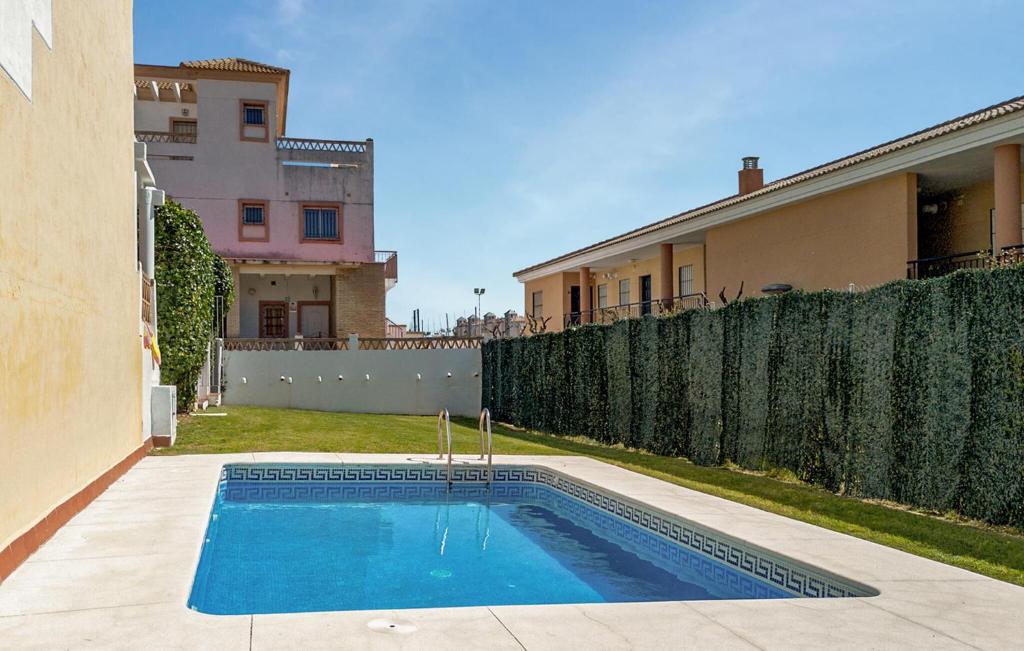 a swimming pool in a yard next to a house at Awesome Home In Islantilla - Lepe in Islantilla