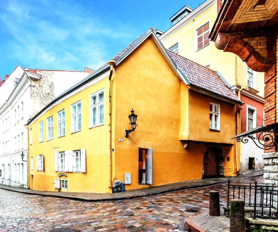 un edificio amarillo al costado de una calle en Cozy nest in the old town, en Tallin