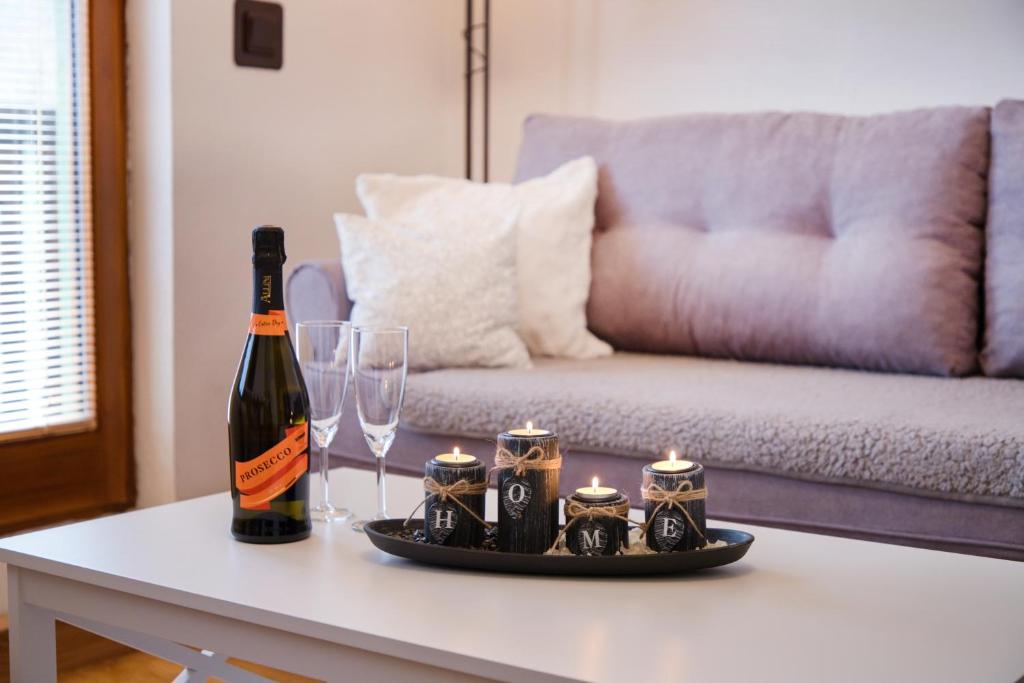 a bottle of wine on a table with candles and wine glasses at Apartmán Ivka in Brezno