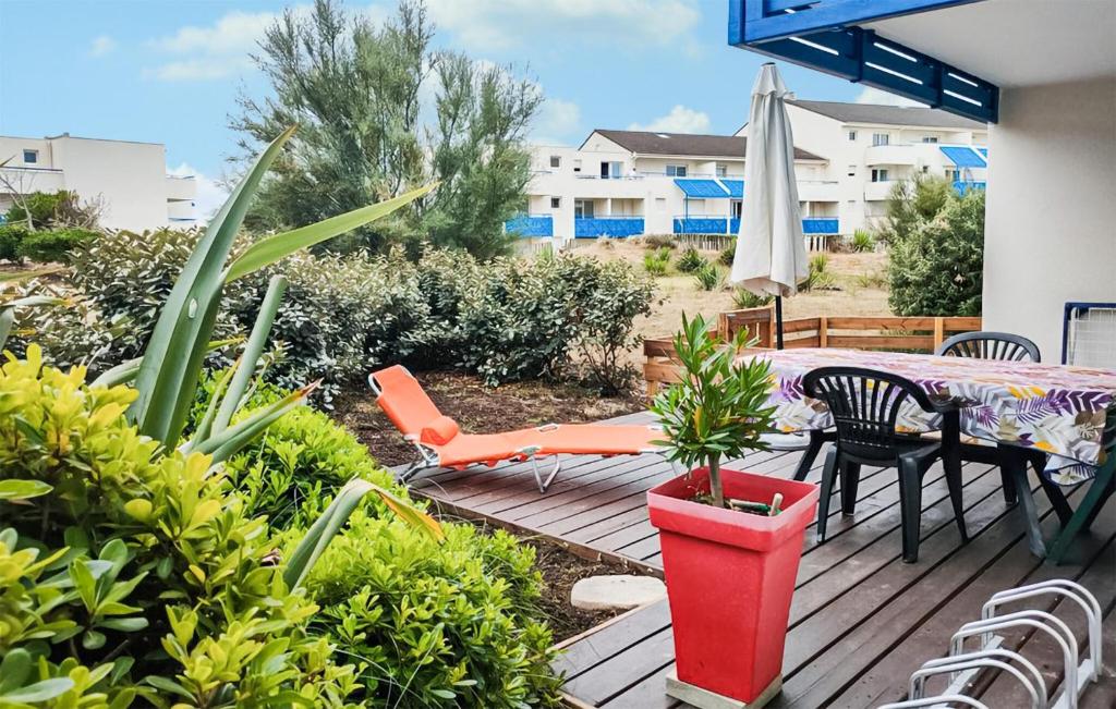 una terrazza con tavolo, sedie e ombrellone di Pet-Friendly Apartment In Lacanau a Lacanau