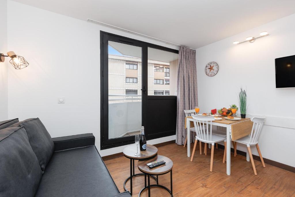 un salon avec un canapé et une table dans l'établissement Slim YourHostHelper, à Cannes