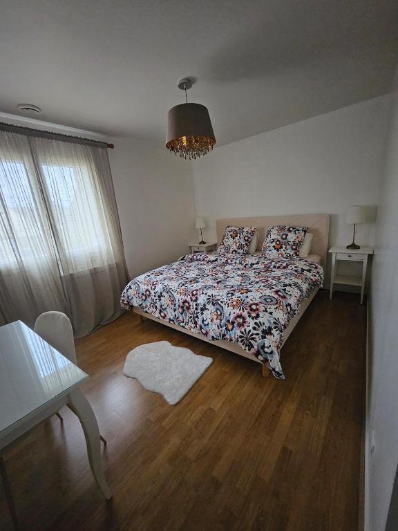 une chambre avec un lit avec un couvre-lit fleuri dans l'établissement Maison entiere avec Terrasse proche A1 CDG Asterix, à Saint-Witz