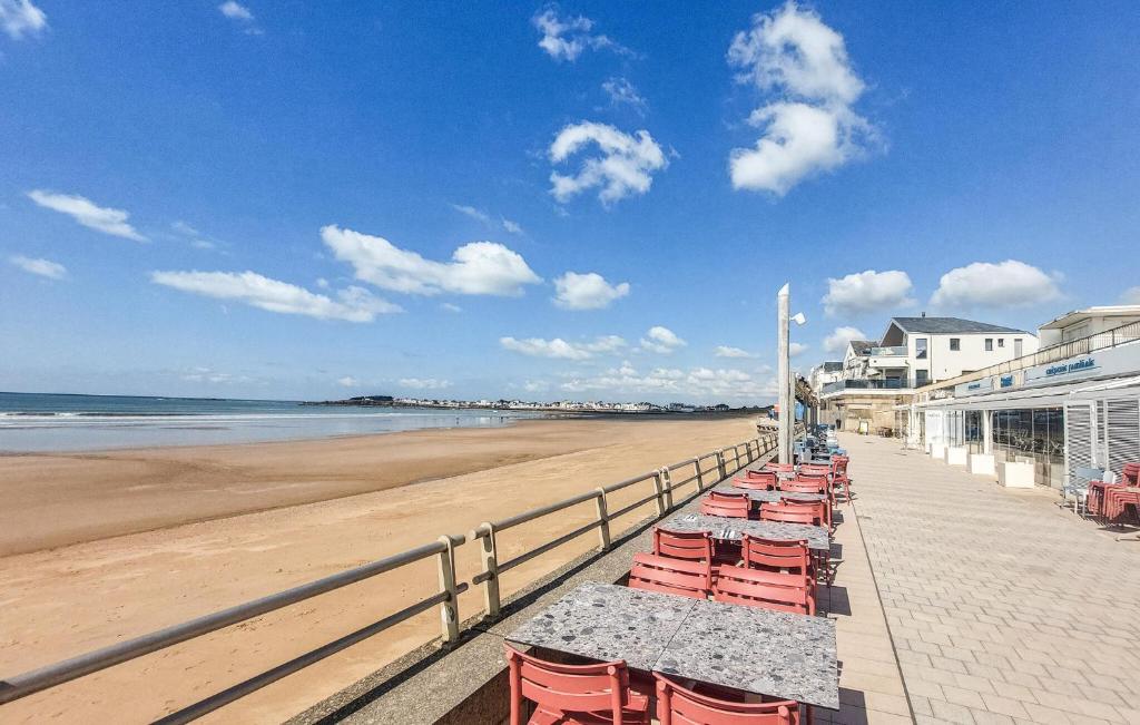 - une rangée de tables et de chaises sur la plage dans l'établissement Stunning Apartment In Saint-Gilles-Croix-De-, à Le Sablais