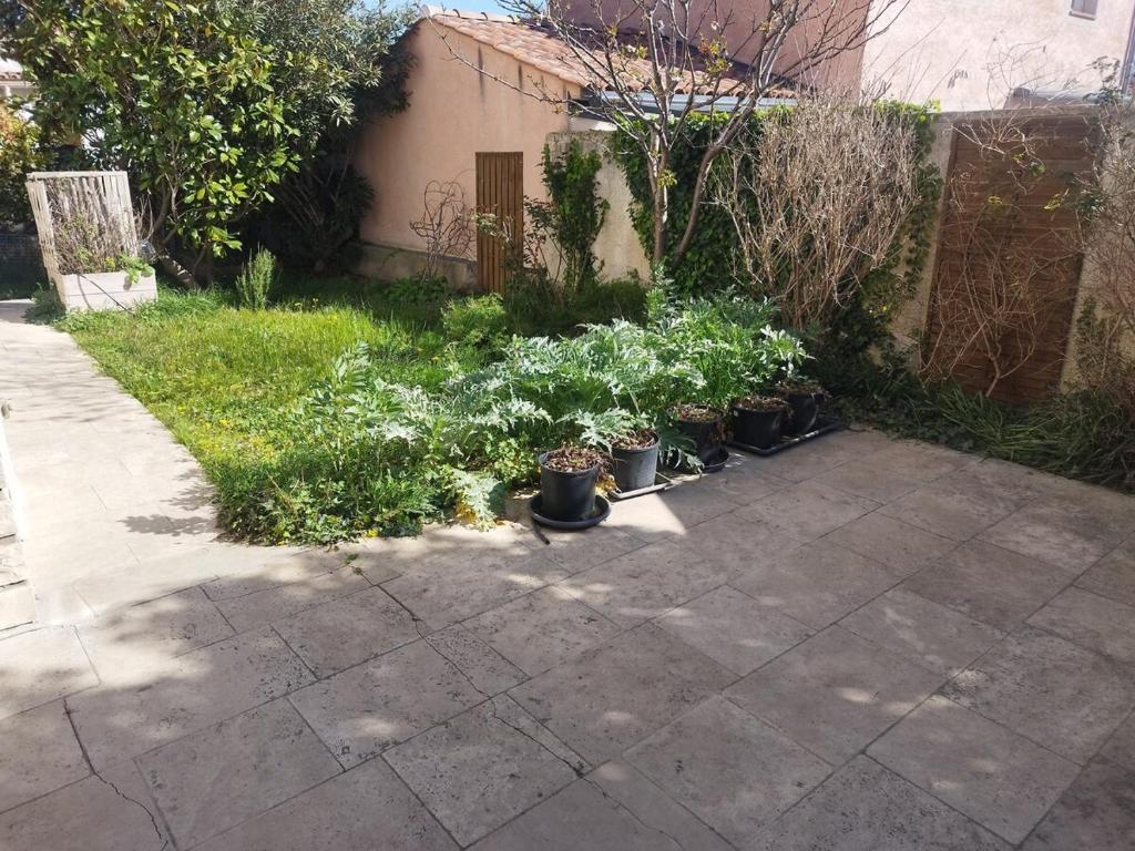 - un jardin avec des plantes en pots sur une terrasse dans l'établissement L'ensoleillé, à Aubagne