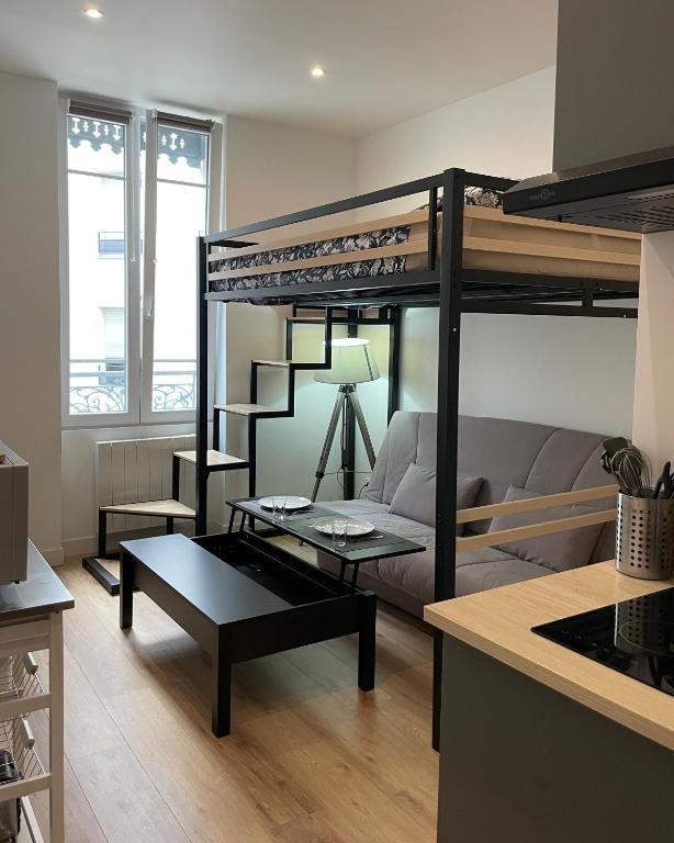 un salon avec un lit superposé et un canapé dans l'établissement T1 Le Aynard, à Villeurbanne
