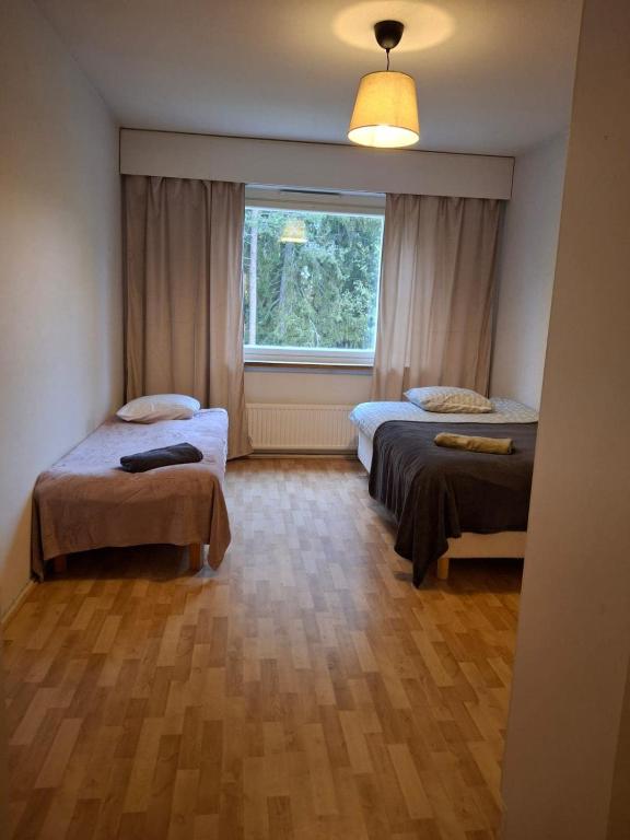 a room with two beds and a window at Myllymäki 22 X in Lahti