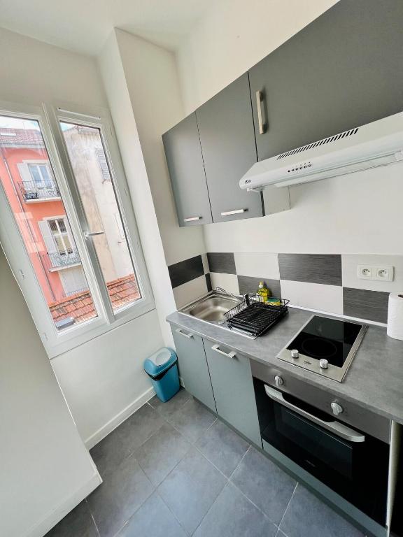 Il comprend une cuisine équipée d'une cuisinière et d'un évier. dans l'établissement Charmant studio moderne équipé à Nice, à Nice