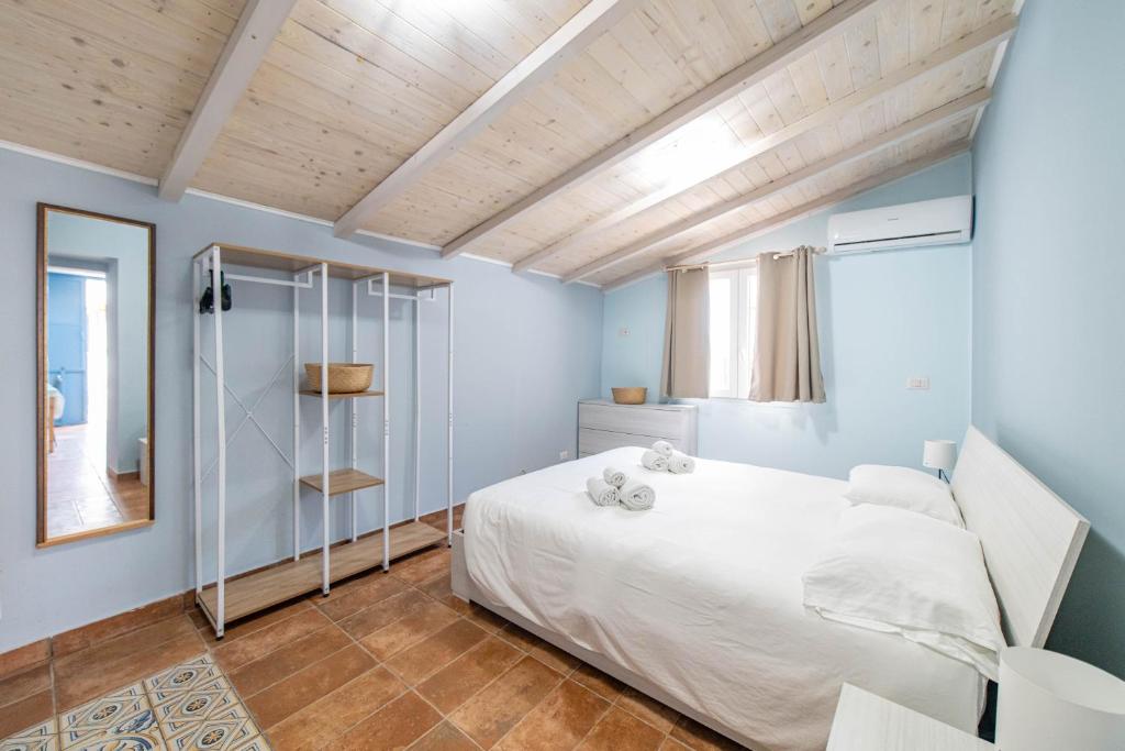 une chambre avec un lit blanc et un plafond en bois dans l'établissement Villa Venere Sicily, à Piedimonte Etneo
