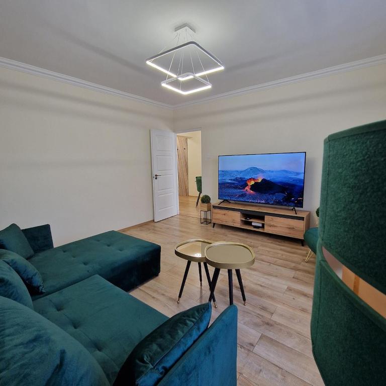 a living room with a couch and a tv at Central Greatforest Apartman 2 in Debrecen