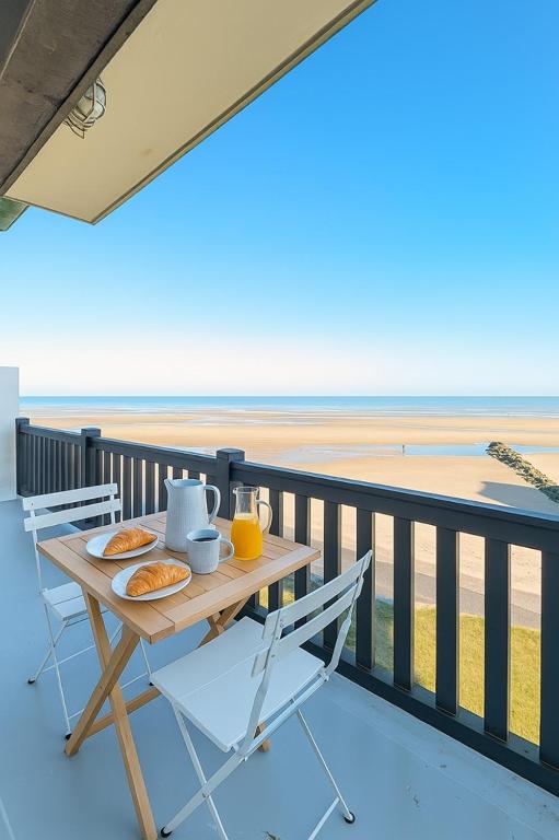 - une table avec petit-déjeuner sur un balcon donnant sur la plage dans l'établissement L Horizon, F3, vue mer exceptionnelle, 3 ou 4 pers, à Blonville-sur-Mer