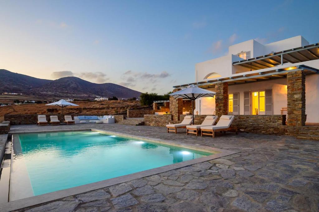 a villa with a swimming pool and a house at Soho Villa in Paros in Chrissi Akti