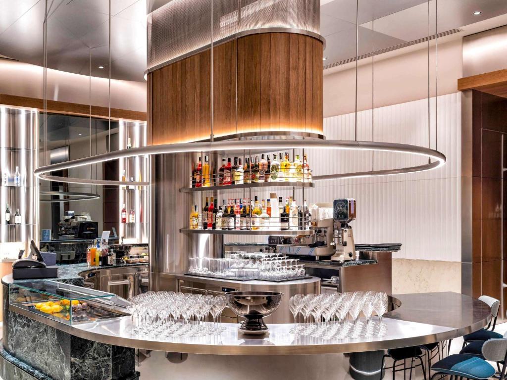 a restaurant with a bar with wine glasses at Palazzo Tirso MGallery Cagliari in Cagliari