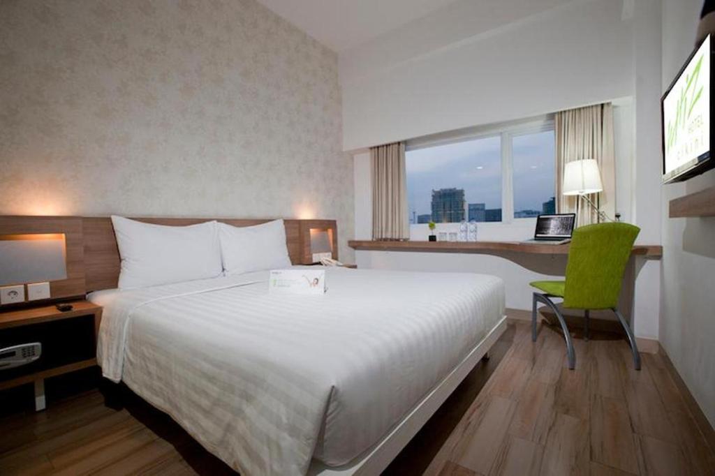 Postel nebo postele na pokoji v ubytování Whiz Hotel Cikini Jakarta