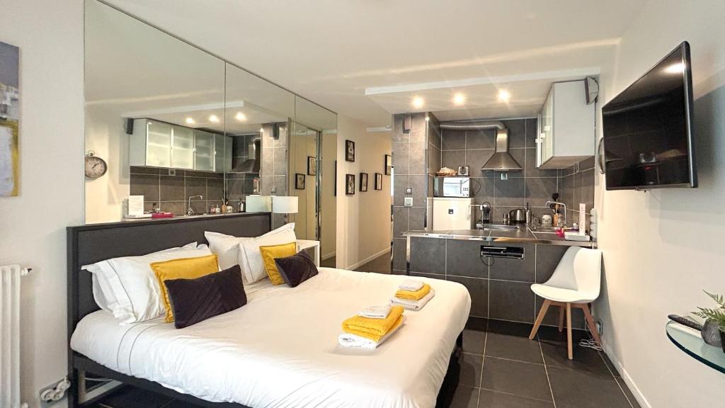 - une chambre avec un grand lit blanc et des oreillers jaunes dans l'établissement Studio Victoria 200 m Carlton Hotel & Croisette, à Cannes