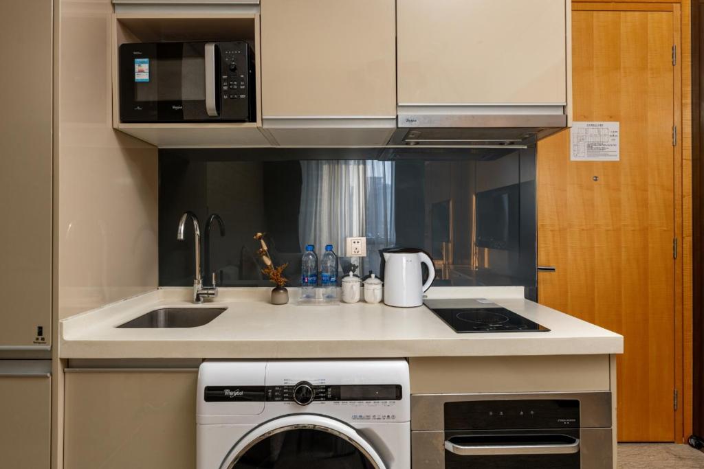 a kitchen with a sink and a dishwasher at Fa万濠国际服务公寓 in Guangzhou