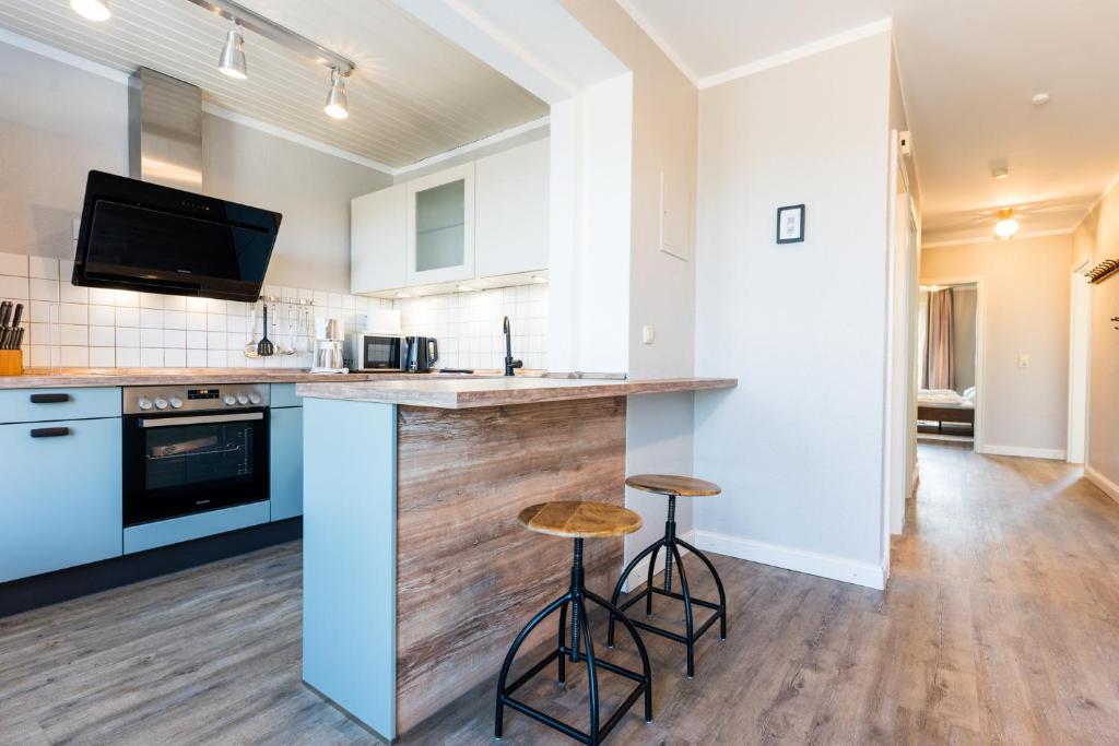 a kitchen with a counter and two stools at Am Hinrichsberg unten in Staberdorf