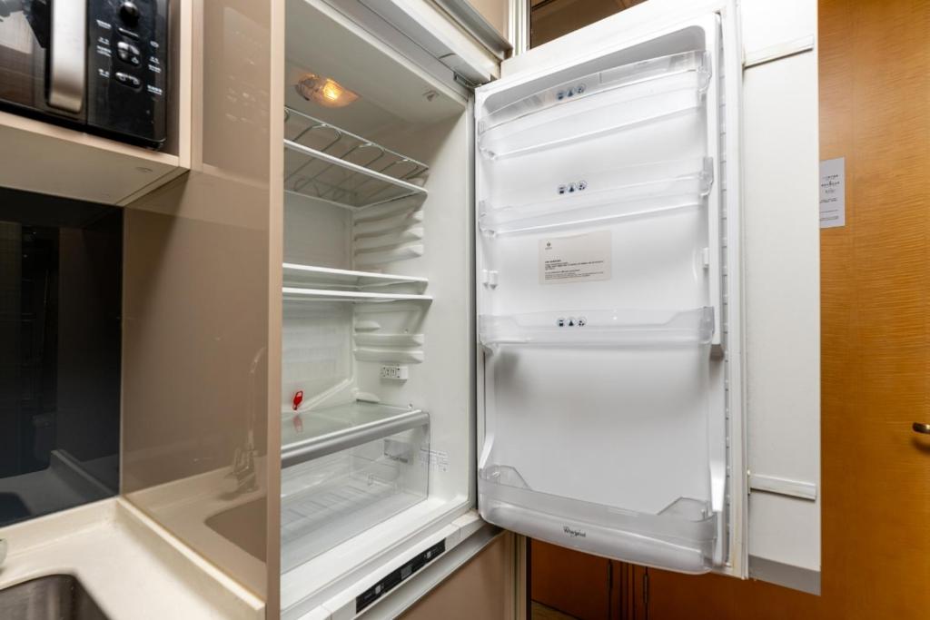 an empty refrigerator with its door open in a kitchen at Fa万濠国际服务公寓 in Guangzhou