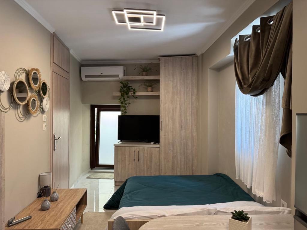 a bedroom with a bed and a tv on a wall at Bloom Garden 1 in Mytilene