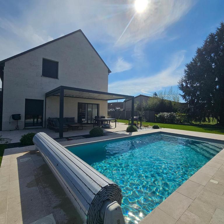 - une piscine avec toboggan en face d'une maison dans l'établissement Villa de prestige Loire Valley, à Saint-Avertin
