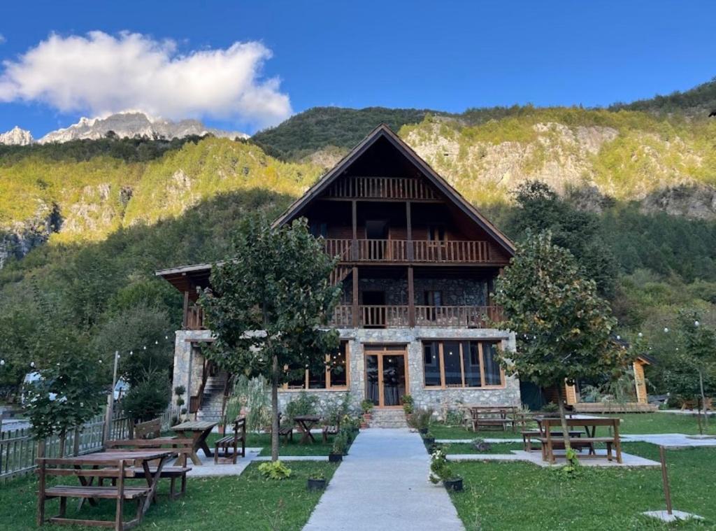 un gran edificio con mesas de picnic delante de él en Alpinehouse, en Theth