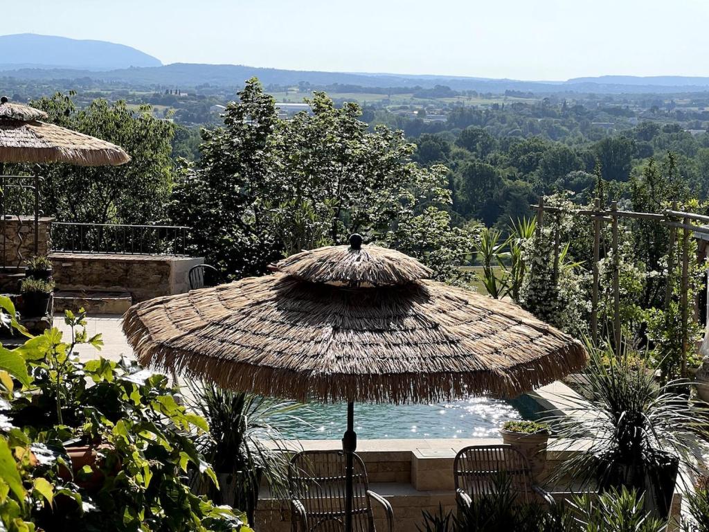 - un grand parasol en paille près de la piscine dans l'établissement GARD, Cévennes, gîte de luxe 5étoiles, 2 personnes avec spa et piscine privatifs, à Saint-Christol-lès-Alès