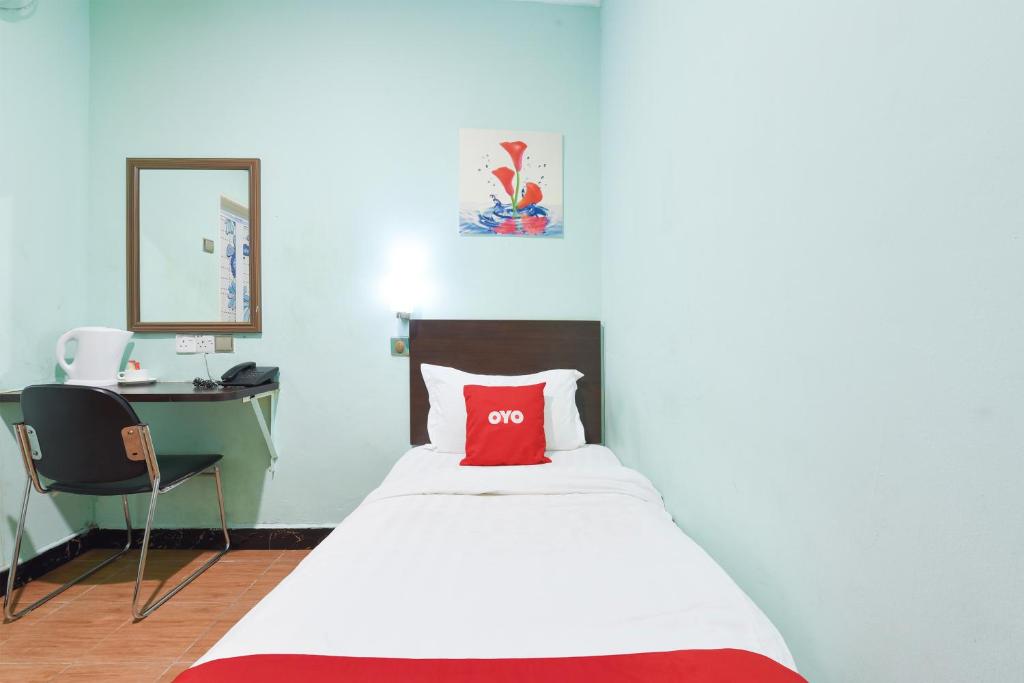 a bedroom with a bed with a red pillow on it at Danceter Destiny Riverside Hotel in Kota Bharu