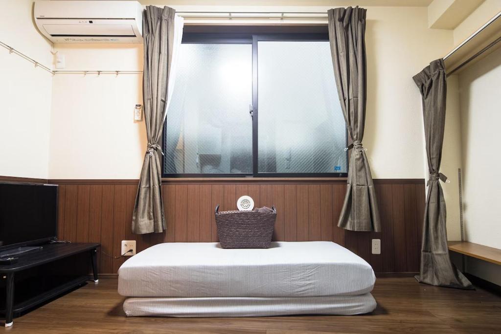 a room with a bed in front of a window at Central Shinjuku, Quiet Area, Close to Station, No Stairs, Room101 in Tokyo