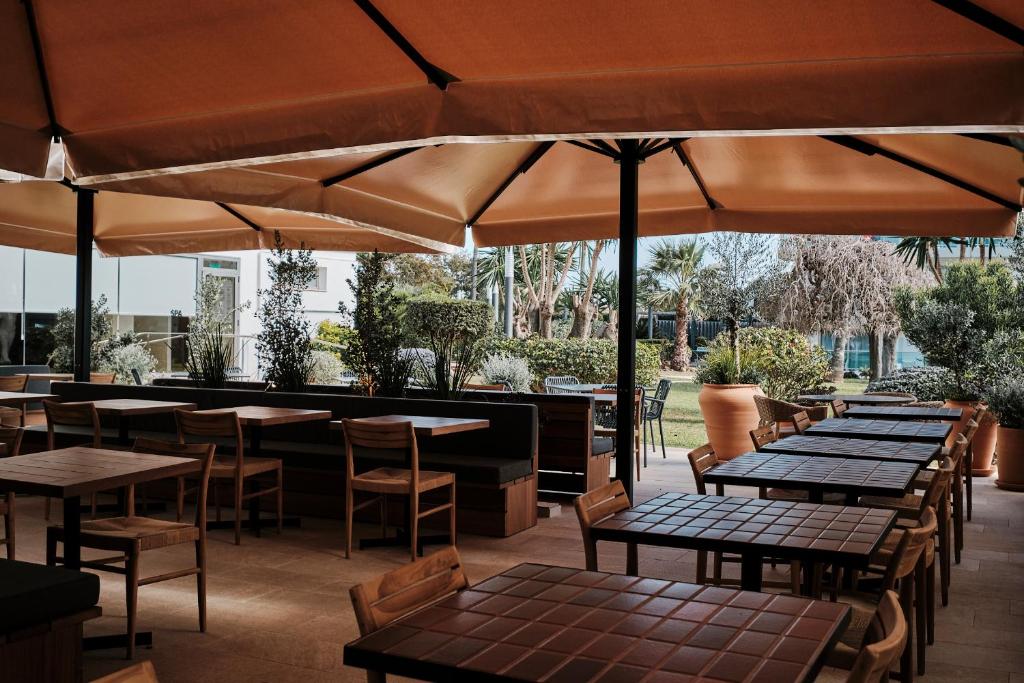 an outdoor patio with tables and chairs and umbrellas at Helios Mallorca Hotel & Apartments in Can Pastilla