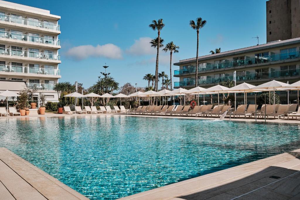 a swimming pool with chairs and a hotel at Helios Mallorca Hotel & Apartments in Can Pastilla