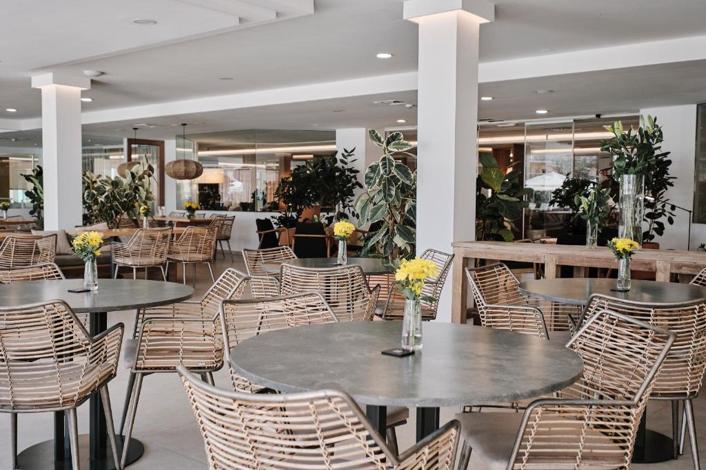 a restaurant with tables and chairs with flowers on them at Helios Mallorca Hotel & Apartments in Can Pastilla