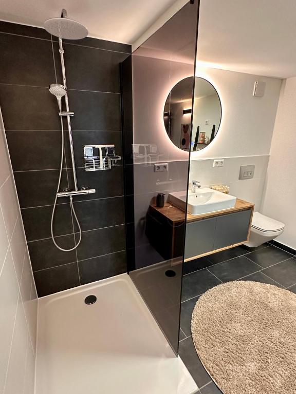 a bathroom with a shower and a sink and a mirror at Ferienwohnung Storchennest in Eisfeld