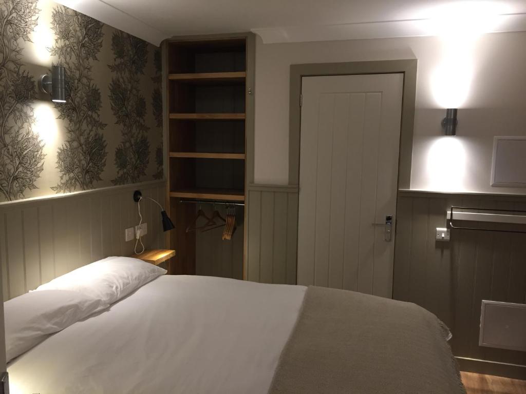 a bedroom with a white bed and a door at The Harbour Guest House in Irvine