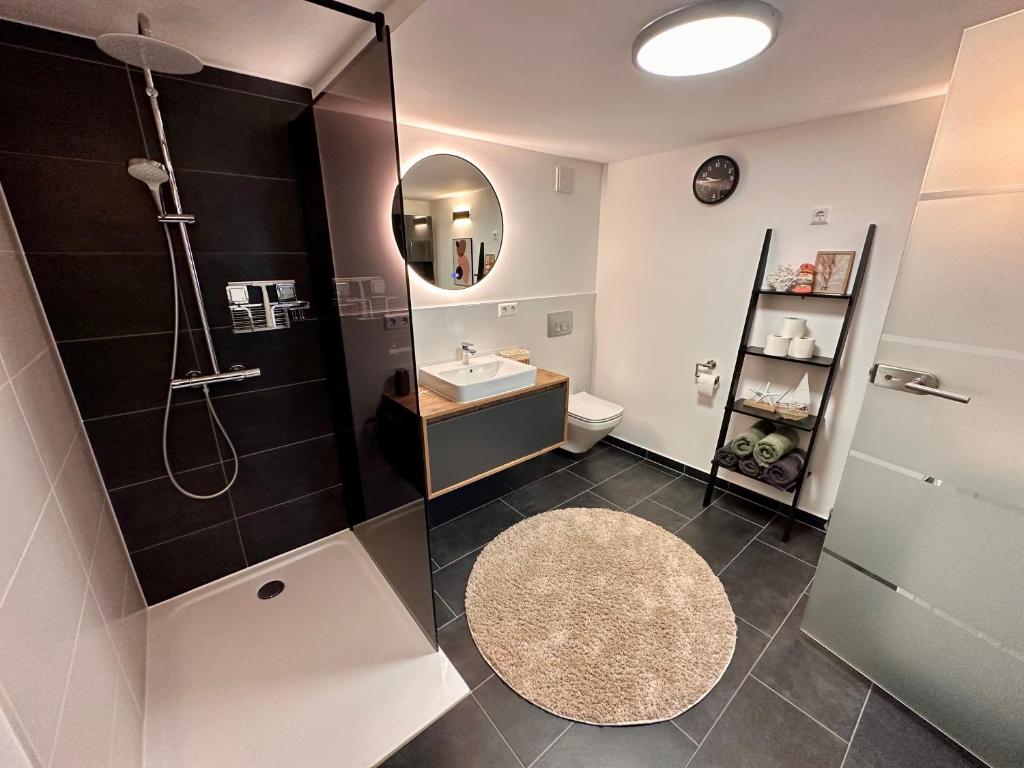 a bathroom with a shower and a sink and a mirror at Ferienwohnung Storchennest in Eisfeld