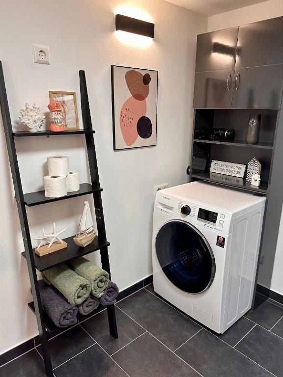 a laundry room with a washing machine and a shelf at Ferienwohnung Storchennest in Eisfeld